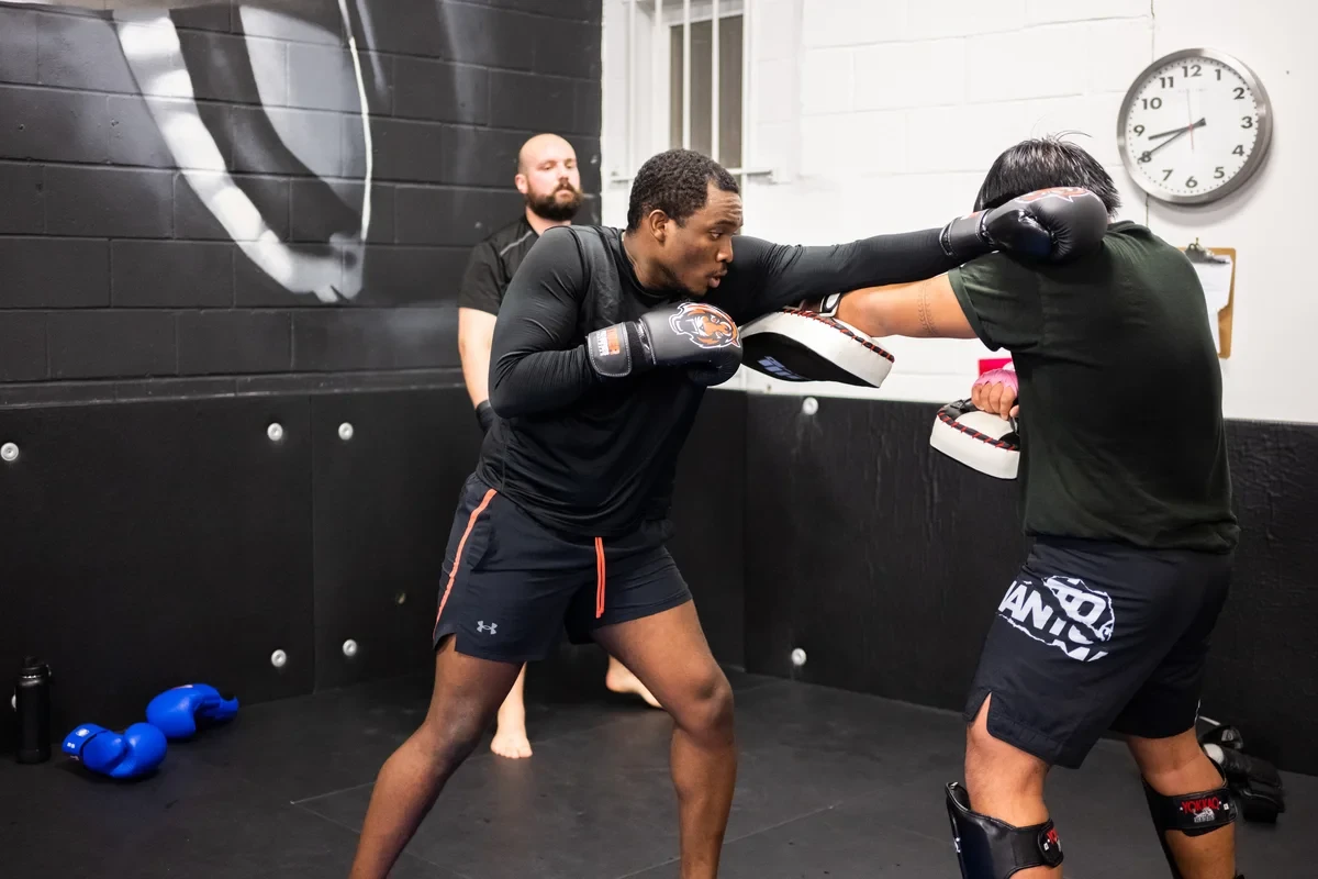 Adult learning proper Muay Thai punch technique with instructor at York academy
